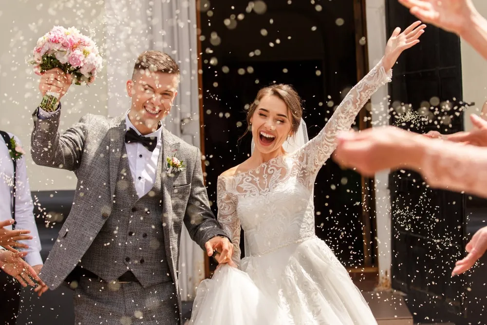 Bride holding a modern hand-tied wedding bouquet featuring seasonal flowers and silk ribbons