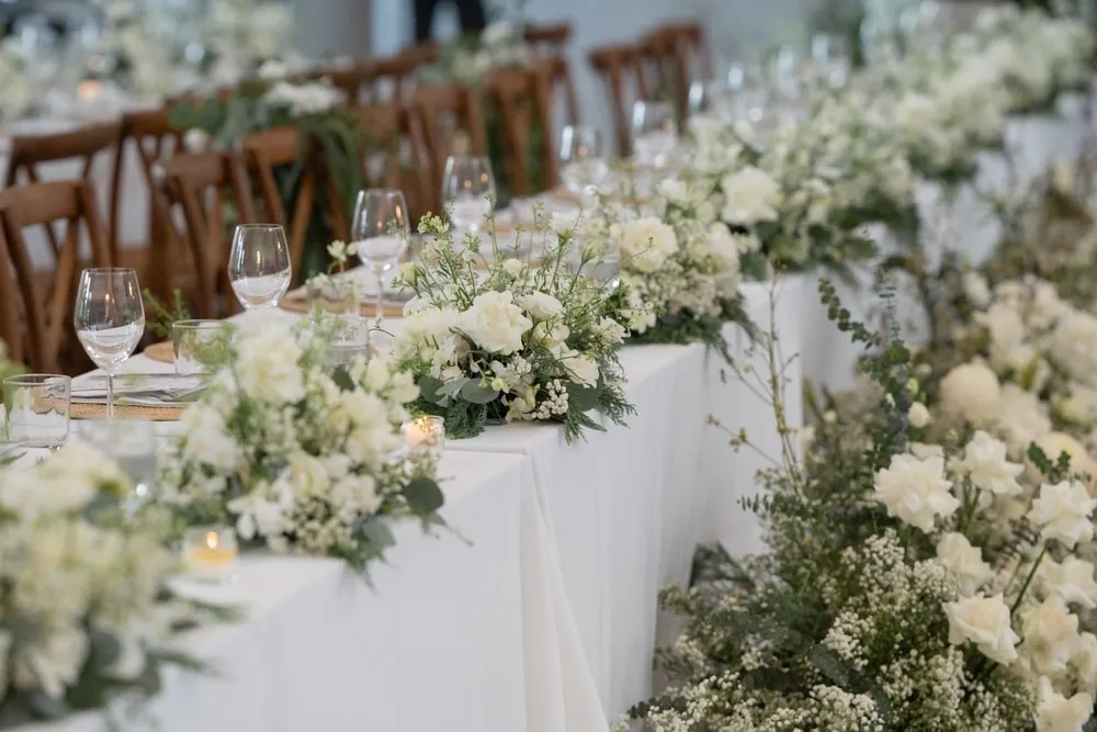 Bride holding a modern hand-tied wedding bouquet featuring seasonal flowers and silk ribbons